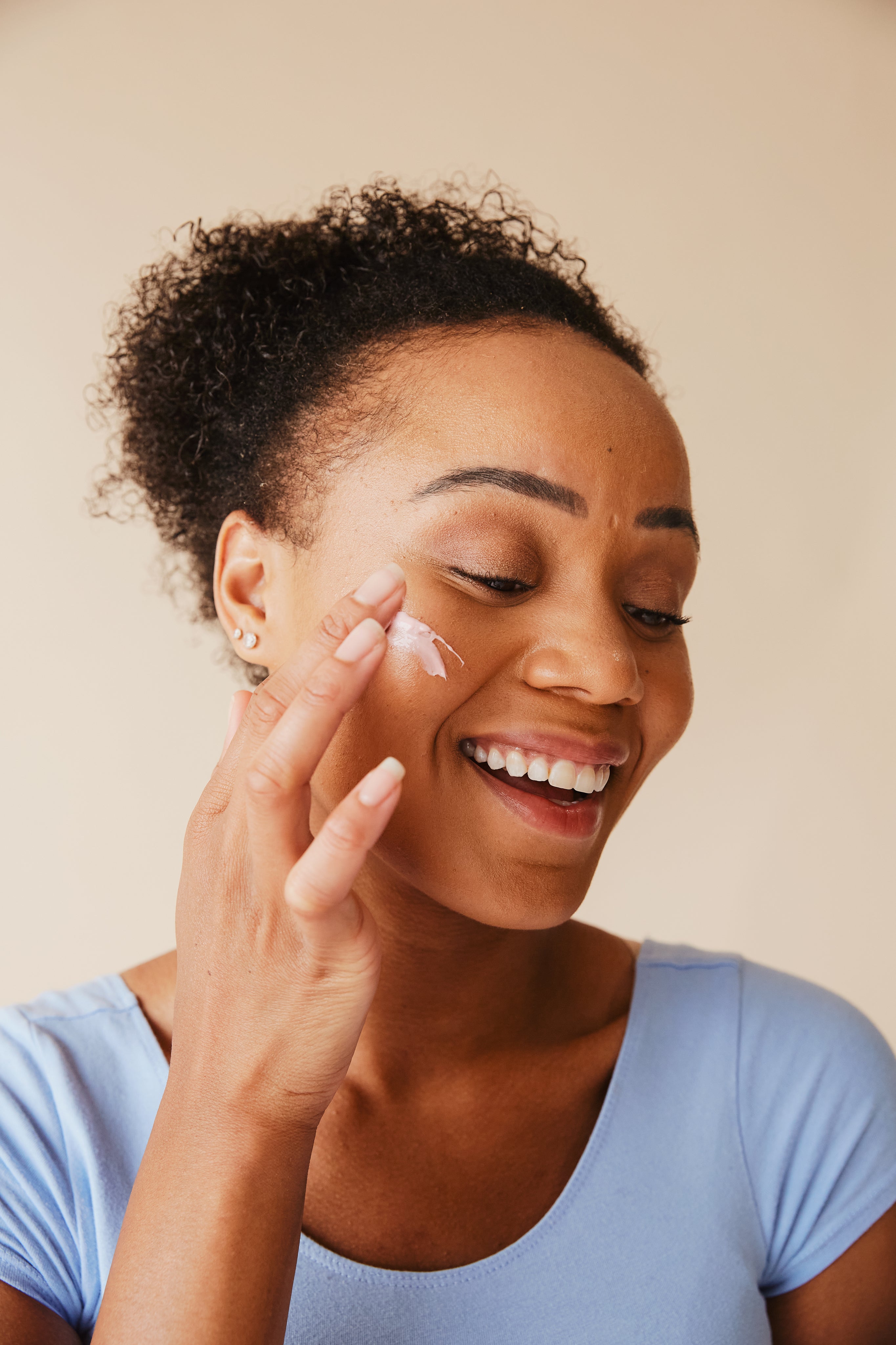 Woman using European facial moisturizer from Nomade Cosmetics for sensitive skin care